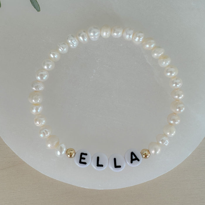 Personalized freshwater pearl bracelet with custom name, initials, or numbers. Timeless pearls + personal touch make it a meaningful gift.