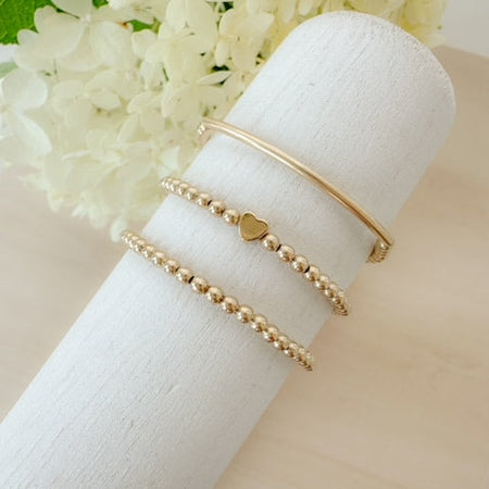 The Golden Lover Stack combines gold-filled bracelets for a stackable, minimalist look that’s timeless, meaningful, and perfect for gifting.