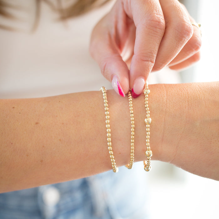 Gold bracelet on a wrist with a blurred background