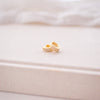 Gold earrings on a soft white fabric background