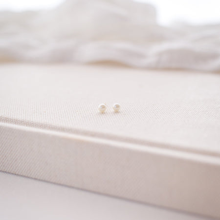 White ribbed knit blanket with a gold tag on a white background