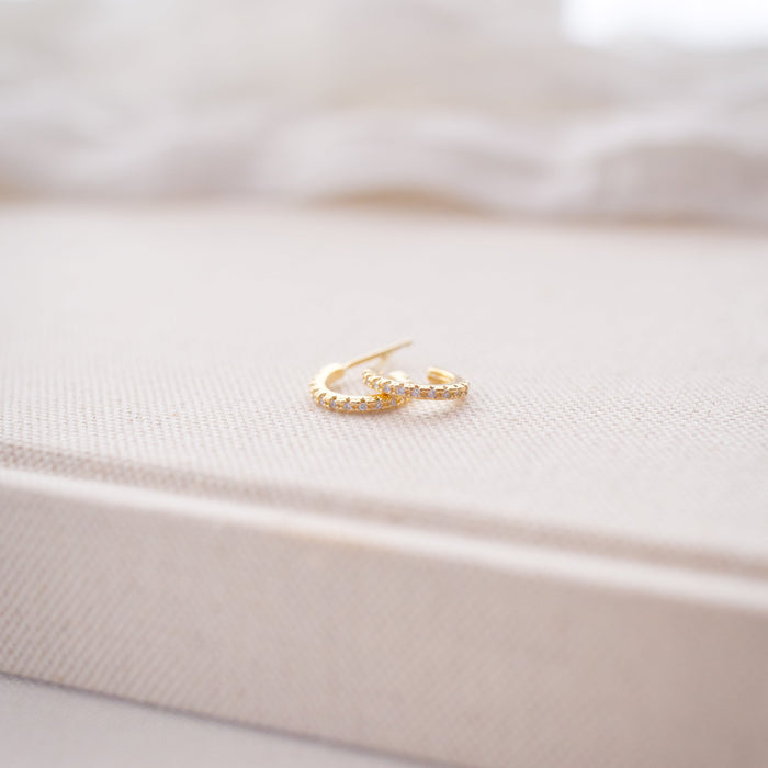 Gold huggies on a white textured surface