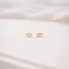 Gold earrings on a soft white fabric background