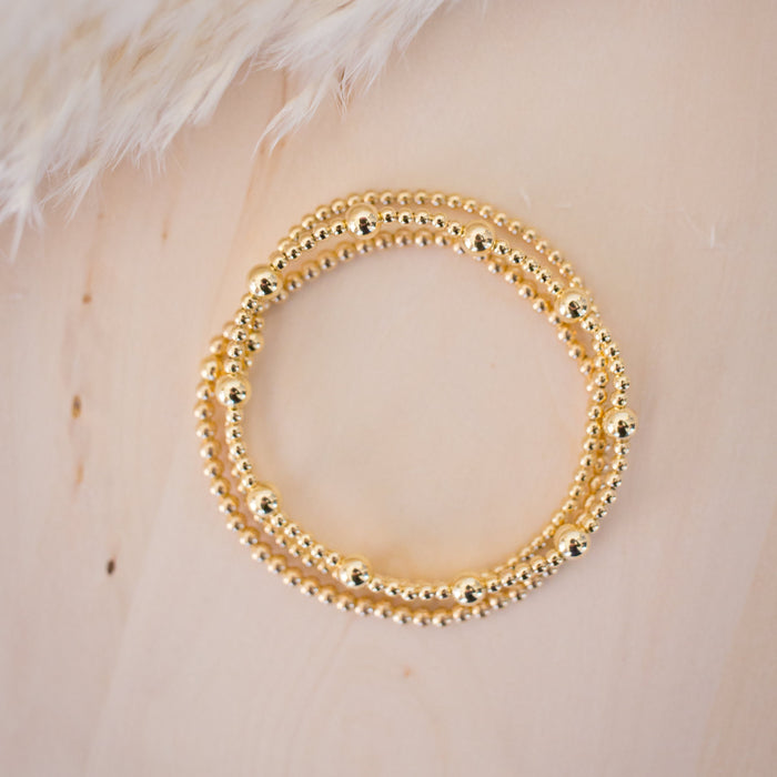 Gold beaded bracelet on a light background