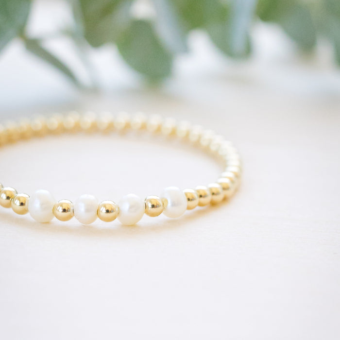 Gold beaded bracelet with single freshwater pearl  close up 