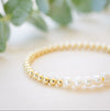 Gold beaded bracelet with single freshwater pearl seven pearl across 