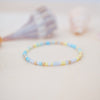 Beaded bracelet with blue and yellow beads on a light background