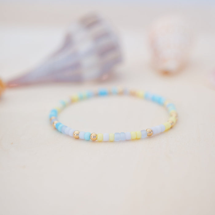 Beaded bracelet with blue and yellow beads on a light background