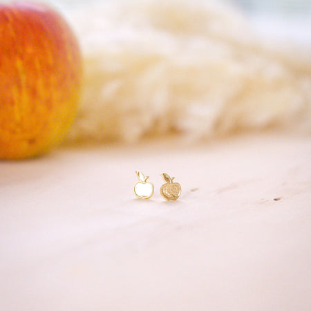 gold filled apple stud with apple in background