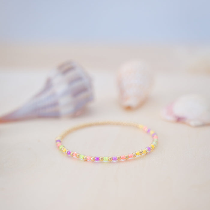 Colorful beaded bracelet on a light surface with a blurred background