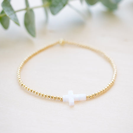 opal white cross on gold beaded bracelet side angle 