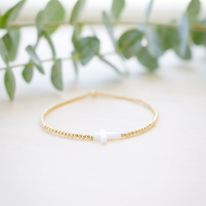 opal white cross on gold beaded bracelet front angle 