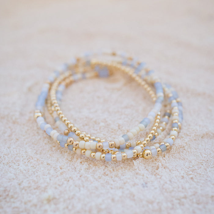 Set of three beaded bracelets on a textured surface