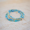 Stack of blue beaded bracelets on a light surface