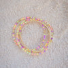 Set of colorful beaded bracelets on a beige sand