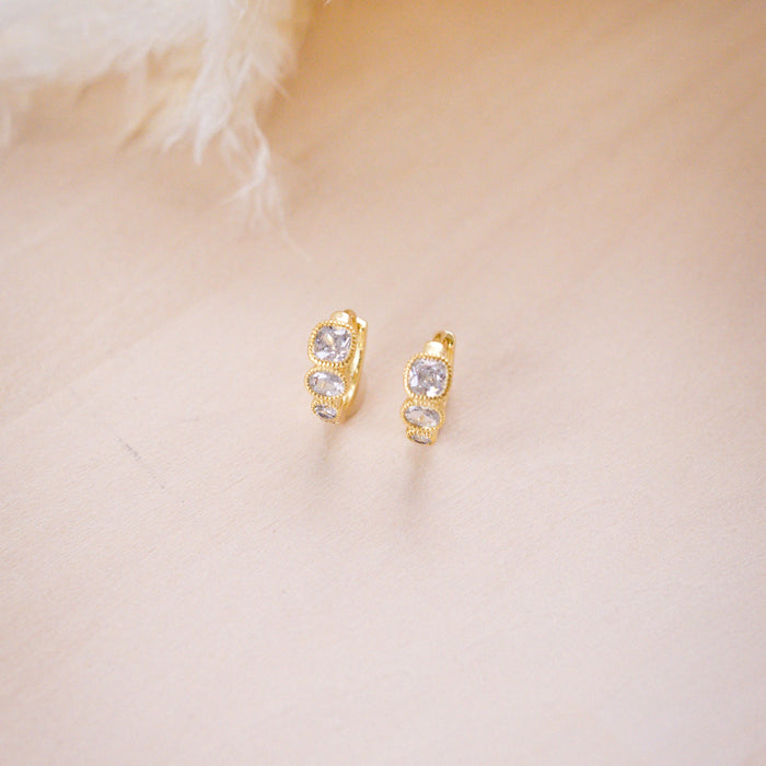 hazel gemstone huggies on wood background