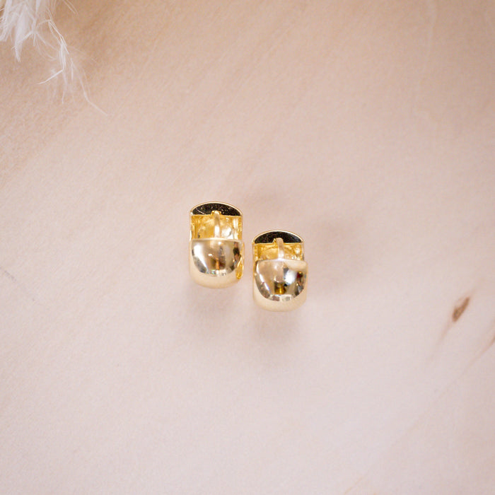 shiny gold fat huggies on wood background, shwoing closure
