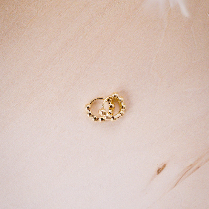 tiny huggies with gold ball texture on wood background
