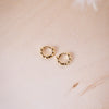 tiny huggies with gold ball texture on wood background