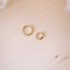 tiny huggies with gold ball texture on wood background shown in two size options