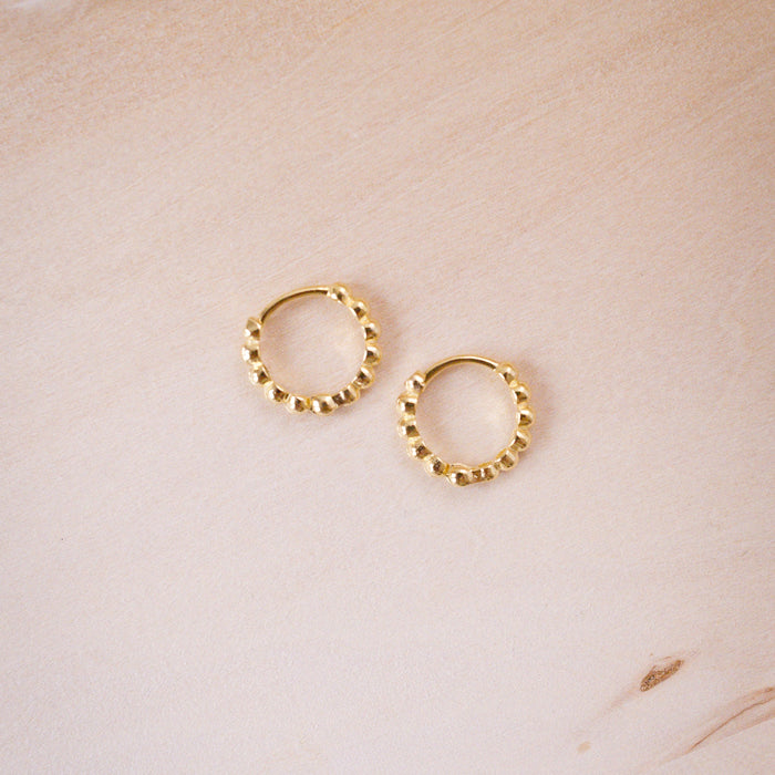 tiny huggies with gold ball texture on wood background