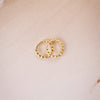 tiny huggies with gold ball texture on wood background