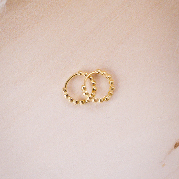 tiny huggies with gold ball texture on wood background