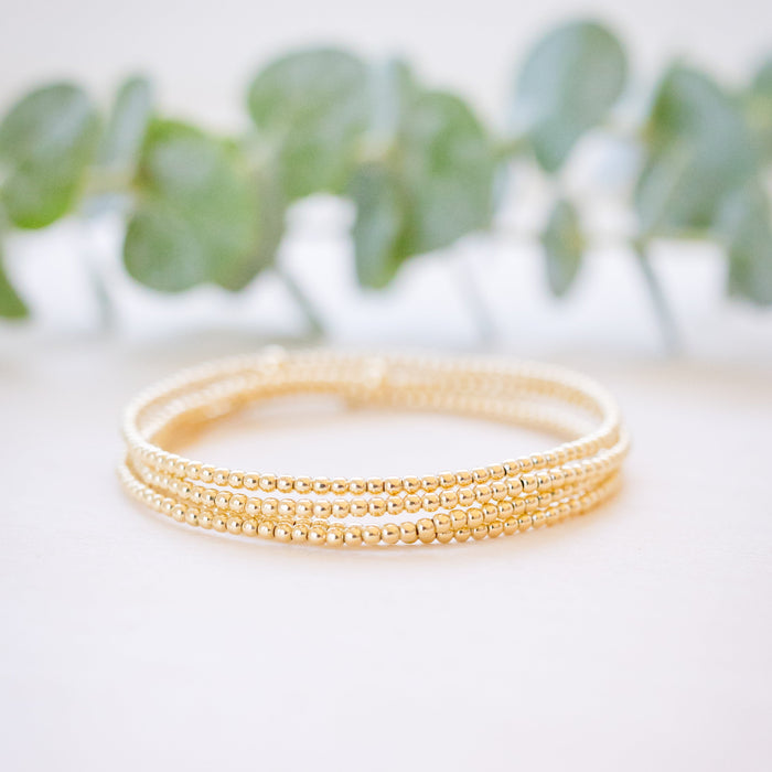 dainty gold beaded bracelet stack of four 