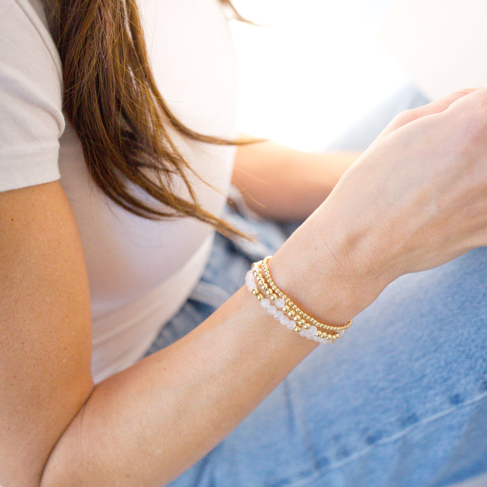 Person wearing a bracelet on a light background