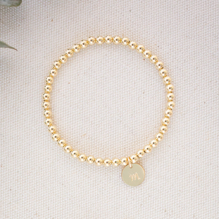 Two pearl bracelets on a light fabric background