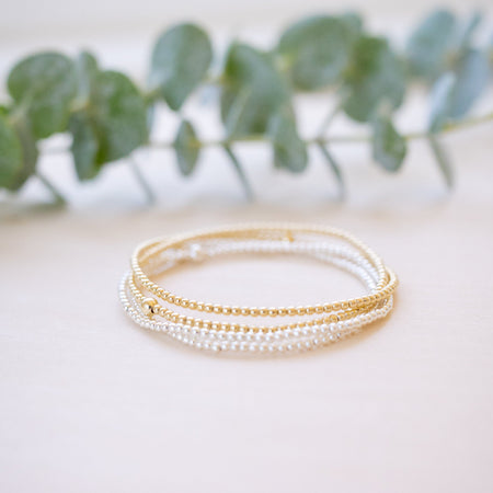 dainty gold beaded bracelet stack of four 