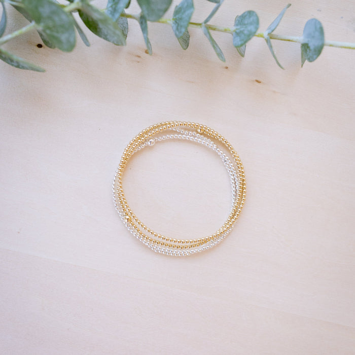 dainty gold beaded bracelet stack of four 