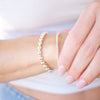 Close-up of a hand wearing a pearl bracelet with a blurred background