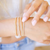 dainty gold beaded bracelet stack of four 