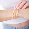 Close-up of a person wearing multiple bracelets on a blurred background