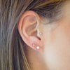 Close-up of an ear with two small earrings.