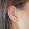 Close-up of an ear with pearl earrings against a blurred background