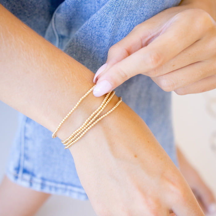 dainty gold beaded bracelet stack of four 