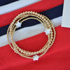 Gold beaded bracelet on a red, white, and blue striped background