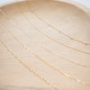Gold chain necklace on a marble surface with a light background