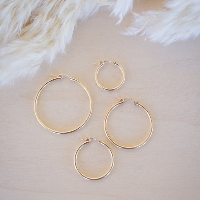 Set of gold hoop earrings on a soft beige background