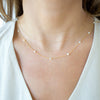 Necklace with small beads on a person wearing a white top