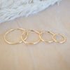 Set of gold hoop earrings on a soft fabric background