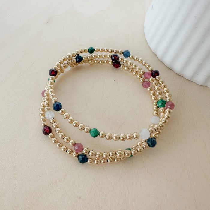 Gemma Bella Bracelet – gold-filled and natural gemstone bracelet with moonstone, malachite, sapphire, pink tourmaline, and garnet. Stackable, colorful, and festive.