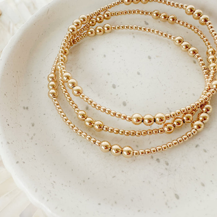 Gold Three-in-a-Row Bead Bracelet – minimalist gold-filled bracelet available as a single piece or stackable set. Perfect for layering, stacking, and everyday wear.