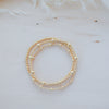 Gold beaded bracelet on a light background