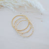 Gold beaded bracelet on a soft white background