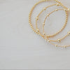 Gold bracelet on a white feather background