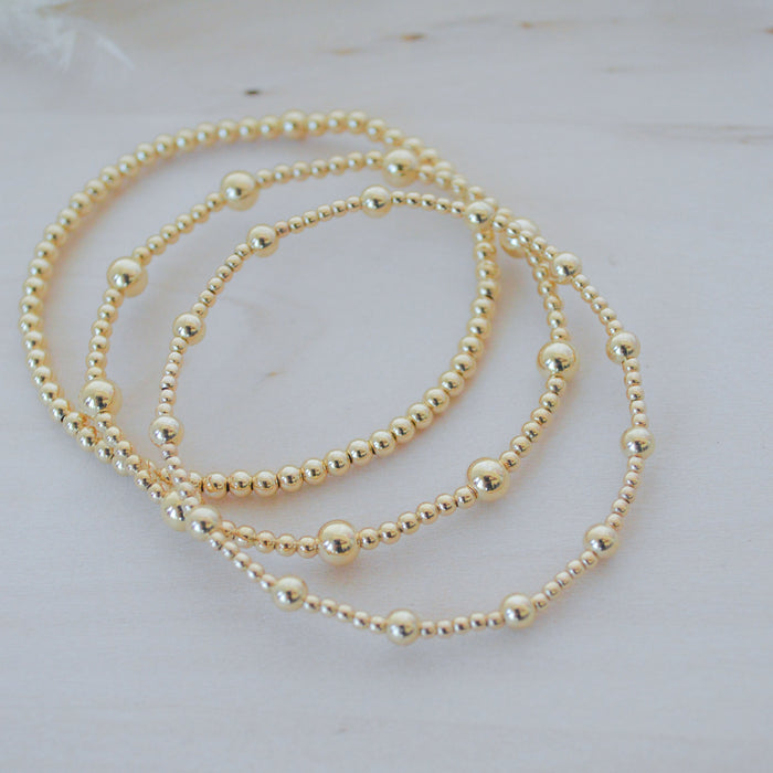 Gold beaded necklace on a light background