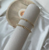 Gold bracelets on a white surface with a soft focus background